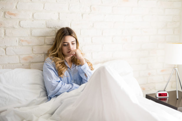 worried-young-woman-thinking-about-something-important-while-sitting-bed-morning-618x412