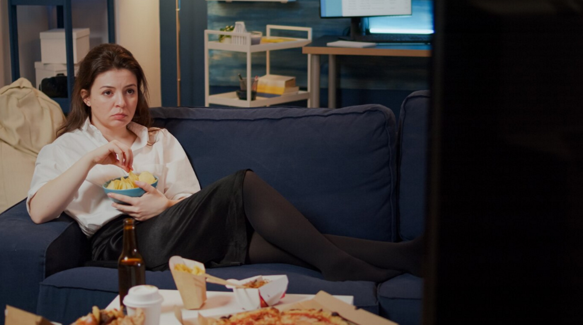 young-woman-laying-couch-holding-bowl-chips-sleep-night