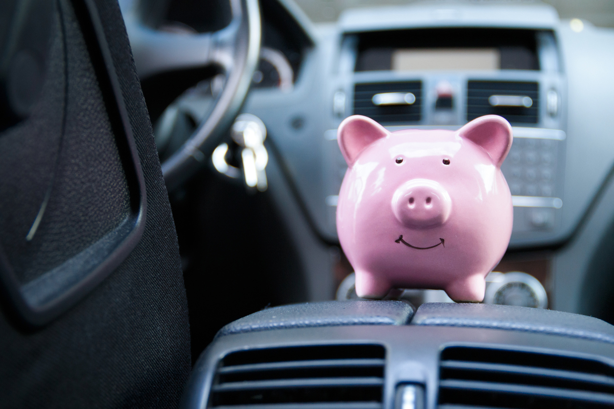 Piggy bank in a car – symbolic image for vehicle purchase, insurance or driving costs