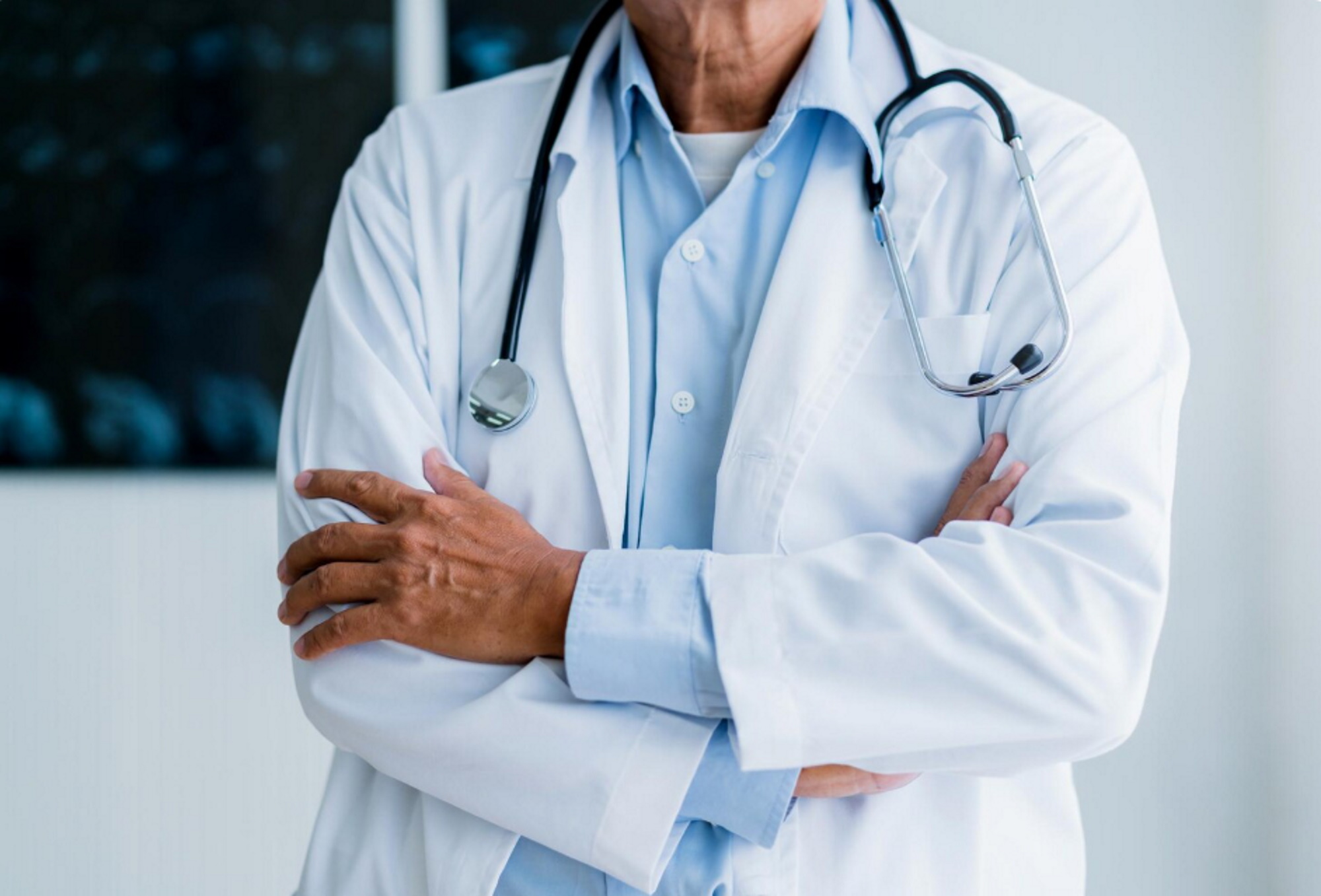 doctor-standing-with-confident-hospital-background-health-ideas-concept
