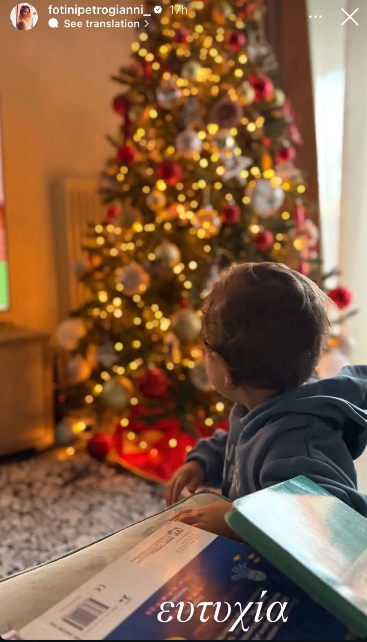 Ο γιος της Φωτεινής Πετρογιάννη μπροστά στο χριστουγεννιάτικο δέντρο