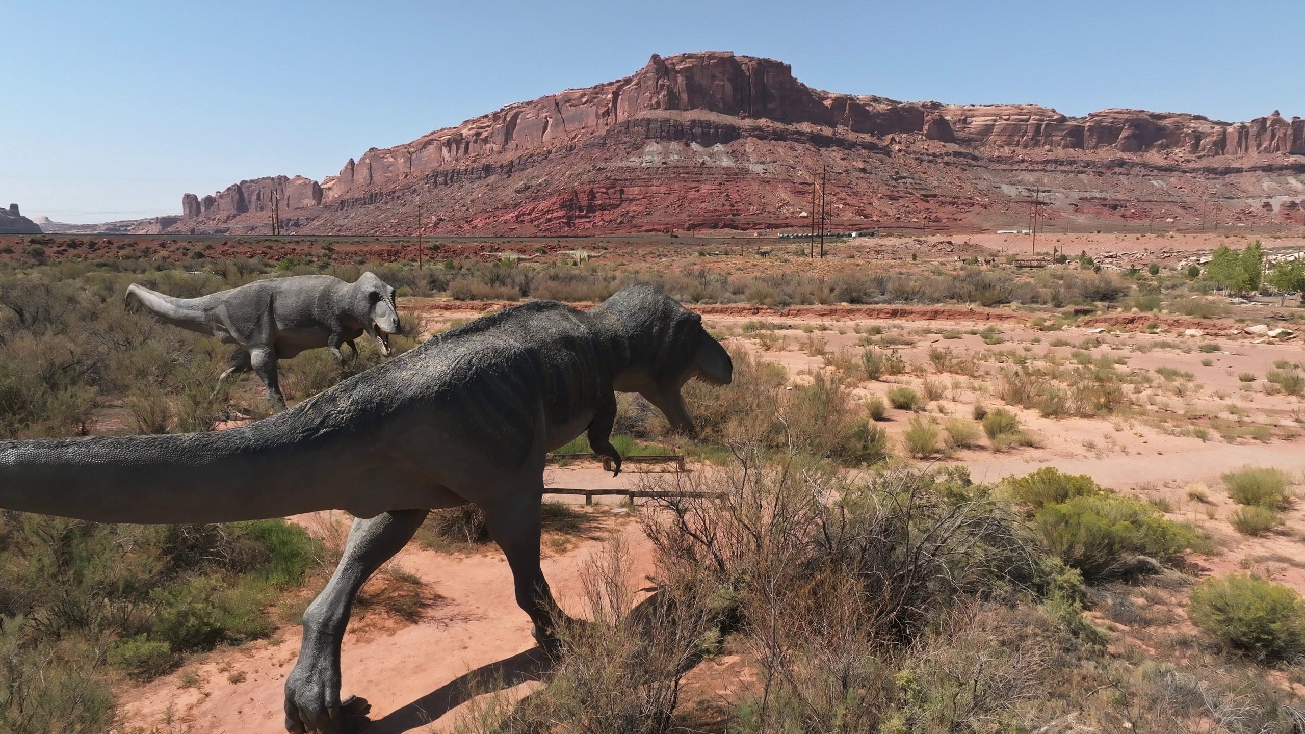 allosaurus-fragilis-as-well-as-tyrannosaurus-rex-or-t-eex-dinosaurs-in-the-moab-desert-SBI-351035514-scaled