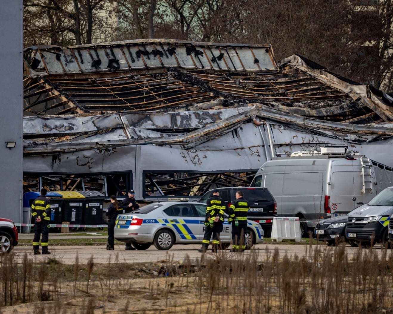 Πυροσβέστες και αστυνομικοί φρουρούν τον χώρο αποθήκης που καταστράφηκε από πυρκαγιά, ιδιοκτησίας της τσεχικής εταιρείας αμυντικού εξοπλισμού LPP Holding, στην πόλη Παρντούμπιτσε της Τσεχίας. (Φωτογραφία: Martin Divíšek/EPA)