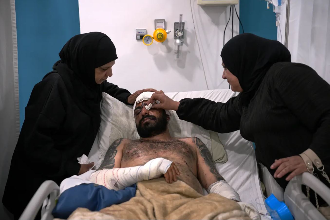 Ο 33χρονος Μαχμούντ Σαχμαράνι ξεκουράζεται σε νοσοκομειακό κρεβάτι, ενώ τον παρηγορούν η μητέρα και η θεία του, μετά τον τραυματισμό του σε ισραηλινό αεροπορικό πλήγμα, στο νοσοκομείο Al-Najda Al-Shaabiya, στη Ναμπατίγιε, νότιος Λίβανος, Παρασκευή 17 Απριλίου 2026, μετά την εκεχειρία μεταξύ Ισραήλ και Χεζμπολάχ. (Φωτογραφία AP/Hassan Ammar)