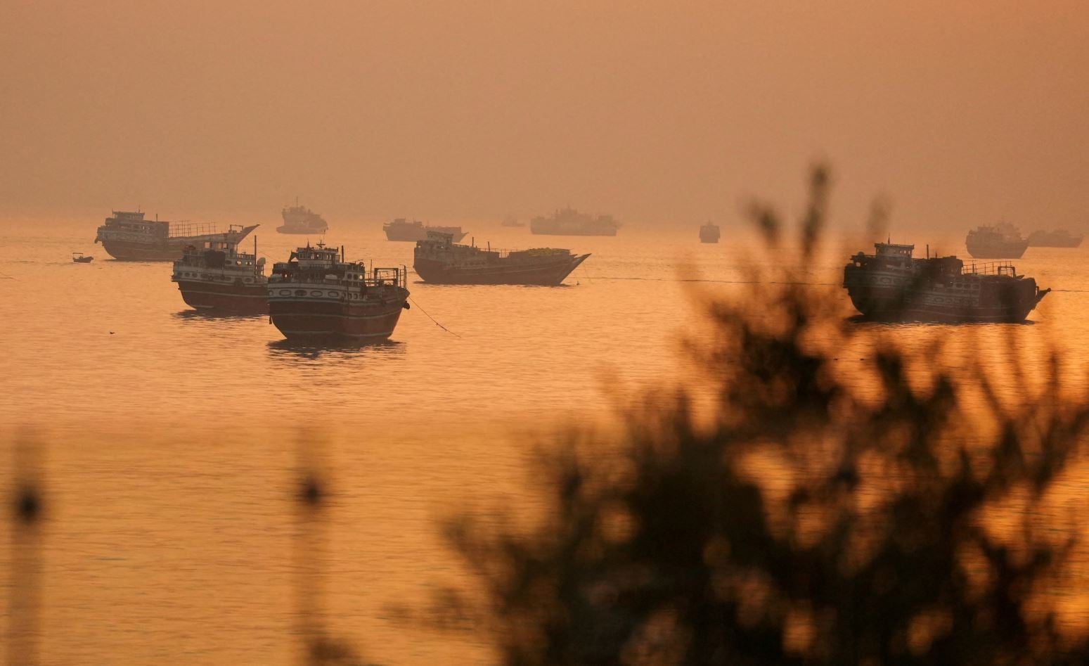 Ιράν: Σχέδιο να κρατήσει τον Τραμπ στον πόλεμο έως τις ενδιάμεσες εκλογές – Ποντάρει στην πολιτική φθορά του 7 Πλοία διέρχονται από τα Στενά του Ορμούζ, όπως φαίνονται από τη χερσόνησο Μουσαντάμ του Ομάν, στις 16 Ιουνίου 2026. (REUTERS/Stringer)