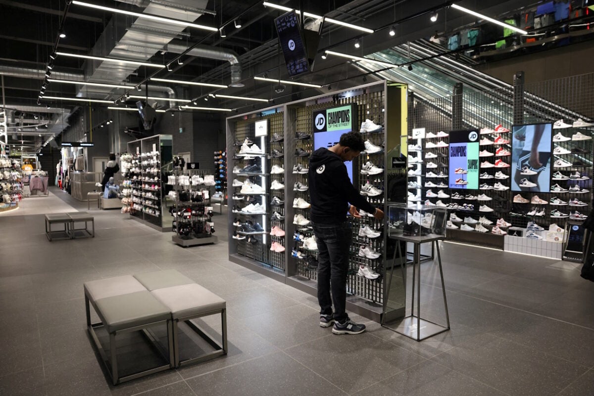 Η JD Sports μειώνει τις προβλέψεις για τα κέρδη λόγω πτώσης στις πωλήσεις 8 FILE PHOTO: A worker adjusts sneakers on display at the JD Sports store at Westfield Stratford City in London, Britain,