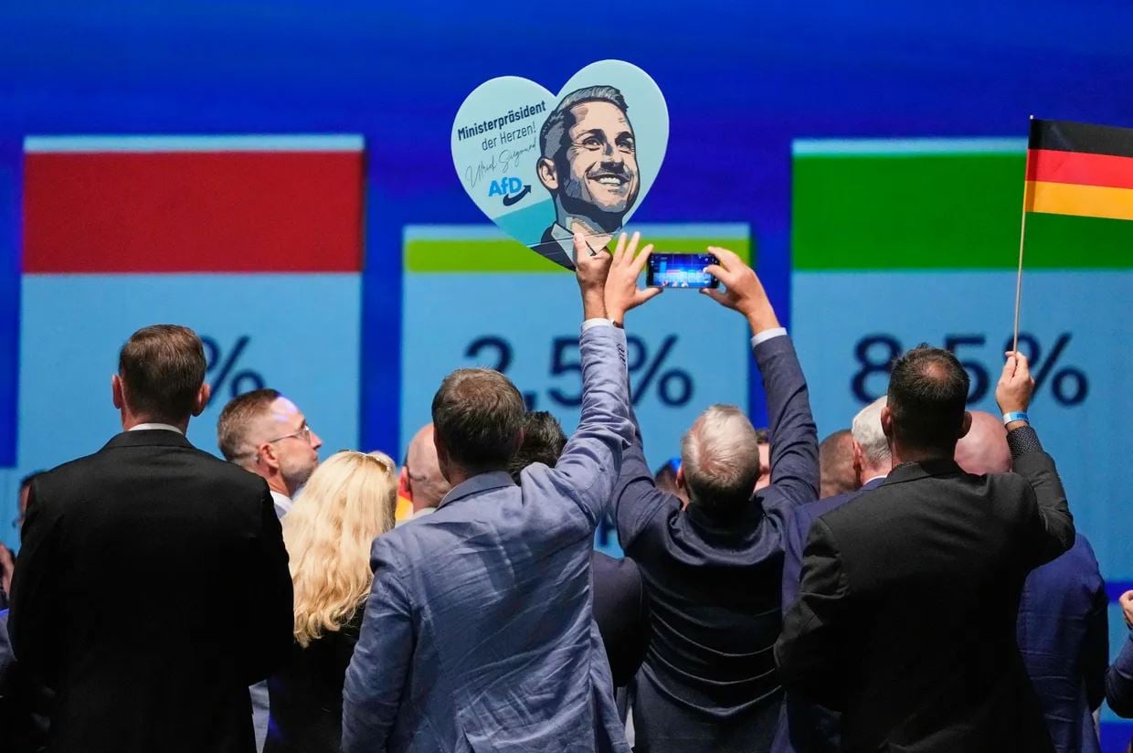 Η σαρωτική νίκη του AfD ξυπνά ξανά τον φόβο της ακροδεξιάς στην Ευρώπη: Γιατί η πορεία της δεν είναι ασταμάτητη 14 Μέλη του AfD πανηγυρίζουν κρατώντας πλακάτ με τον κορυφαίο υποψήφιο του κόμματος, Ούλριχ Ζίγκμουντ, μετά την ανακοίνωση των πρώτων αποτελεσμάτων στις περιφερειακές εκλογές της Σαξονίας-Άνχαλτ, στο Μαγδεμβούργο της ανατολικής Γερμανίας, την Κυριακή 6 Σεπτεμβρίου 2026. Φωτογραφία: AP / Matthias Schrader