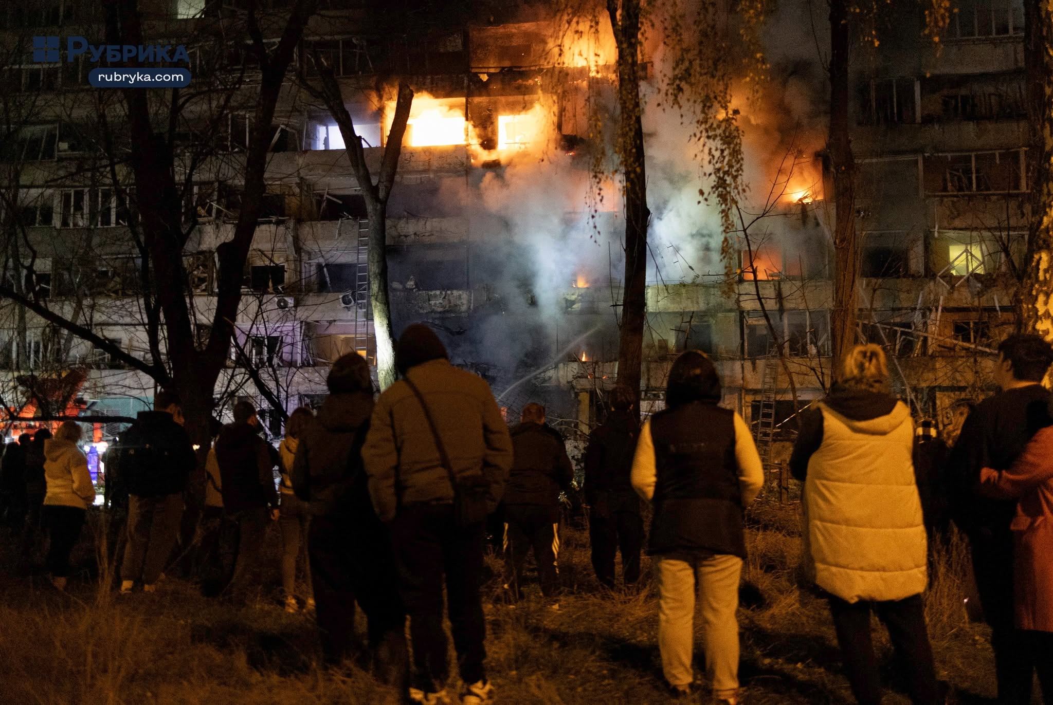 Ουκρανία: Περιορισμοί στο Starshield και ρωσικό σφυροκόπημα κάνουν αφόρητη την καθημερινότητα των αμάχων 12 Κάτοικοι παρακολουθούν πολυκατοικία να έχει τυλιχθεί στις φλόγες, με πυκνούς καπνούς να υψώνονται από τους ορόφους της, μετά τη ρωσική επίθεση στο Κίεβο, την Τρίτη (13/10). Σύμφωνα με τις τοπικές αναφορές, τρεις άνθρωποι σκοτώθηκαν και 22 τραυματίστηκαν στην ουκρανική πρωτεύουσα. (Πηγή: Rubryka / Nick Tymchenko)