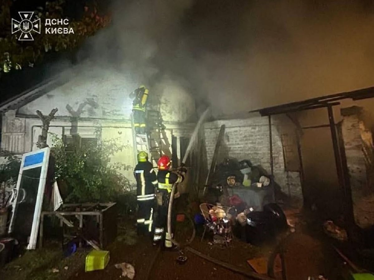 Πυροσβέστες επιχειρούν για την κατάσβεση πυρκαγιάς σε κτίριο στο Κίεβο, με έναν από αυτούς να έχει ανέβει σε σκάλα, καθώς καπνοί υψώνονται από τη στέγη. (Φωτογραφία: Κρατική Υπηρεσία Εκτάκτων Αναγκών της Ουκρανίας)