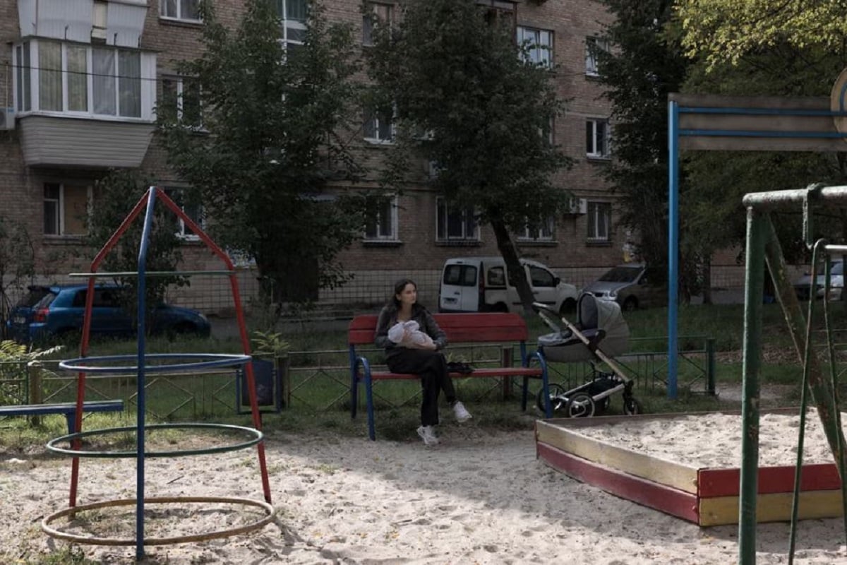 Η Οξάνα Στελμάστσουκ ταΐζει τη νεογέννητη κόρη της, Σοφία, σε παιδική χαρά κοντά στο διαμέρισμά τους στο Κίεβο. Το μωρό γεννήθηκε στις 26 Αυγούστου, την ώρα που ρωσικά drones έπλητταν κτίριο δίπλα στο μαιευτήριο. Φωτογραφία: Jędrzej Nowicki/The New York Times
